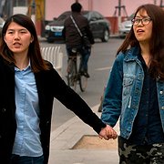 Den kinesiska aktivisten Li Tingting (till vänster) tillsammans med sin flickvän, som bara vill bli identifierad som Teresa, på en gata i en förort till Peking. Efter 37 dagar i häkte frigavs Li Tingting och fyra andra aktivister mot borgen.