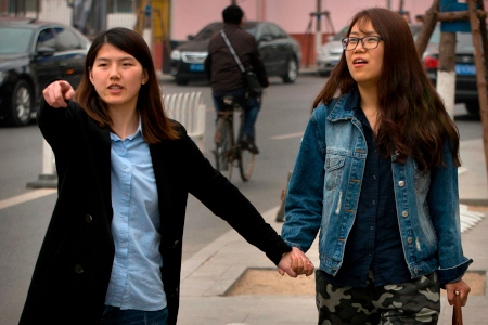Den kinesiska aktivisten Li Tingting (till vänster) tillsammans med sin flickvän, som bara vill bli identifierad som Teresa, på en gata i en förort till Peking. Efter 37 dagar i häkte frigavs Li Tingting och fyra andra aktivister mot borgen.