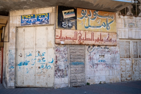 De palestinska butiksägarna har fått bomma igen sedan huvudgatan Shuhada Street varit avstängd för dem de senaste tre decennierna. Här och var har bosättarna i stället satt upp egna skyltar.